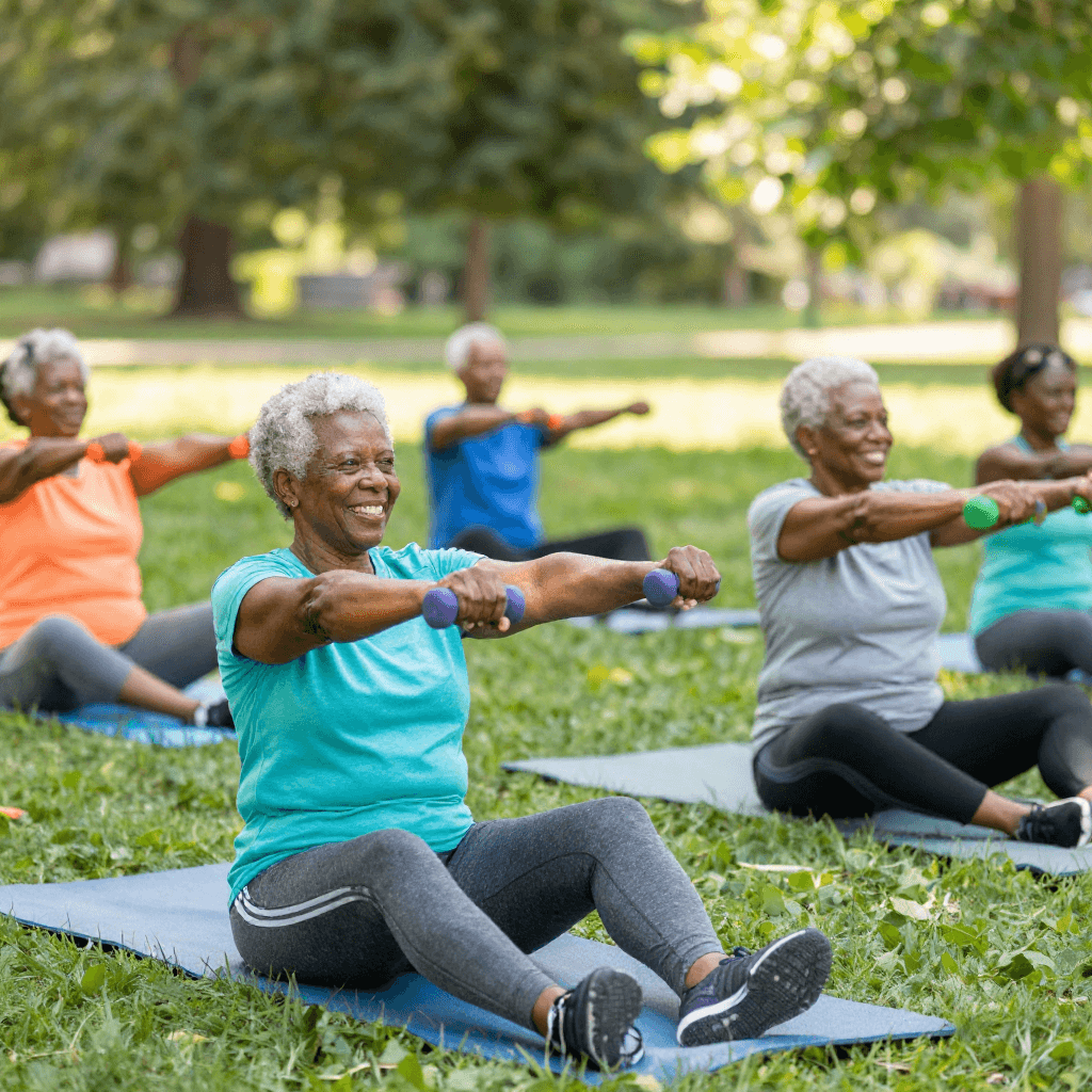 A group of joyful Black and African senior citizens laughing and connecting after an outdoor fitness class